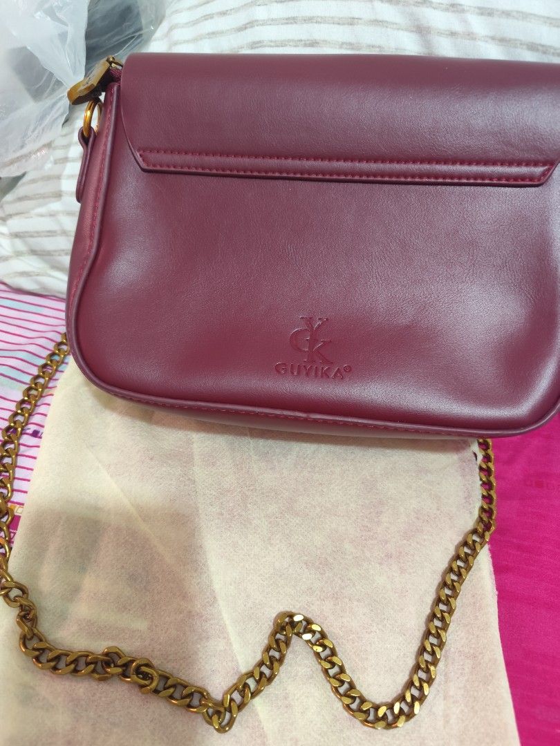 GUYIKA Burgundy Chain Shoulder Bag (Category: Shoulder Bags) located in Manila. Submitted by marriage031073advocate (Listing ID 1464458344, Image 2). Description: - Chic burgundy shoulder bag - Elegant gold clasp closure - Detachable chain strap for versatility - Embossed GUYIKA logo on the back - Ideal size for carrying your essentials - Perfect for casual outings or evening events.