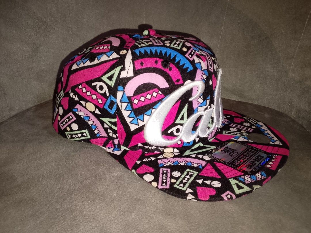 Headlines Cali 90s Aztec Geometric Print Pink Black Snapback Hat (Category: Caps & Hats) located in Binangonan. Submitted by yuristalin888 (Listing ID 1464397589, Image 3). Description: Vibrant 90s-style Aztec geometric and abstract pattern featuring bright pink, black, blue, and green tones, highlighted by a large embroidered white "Cali" script logo on the front crown. * **Style:** Structured flat-brim snapback cap complete with the original "H