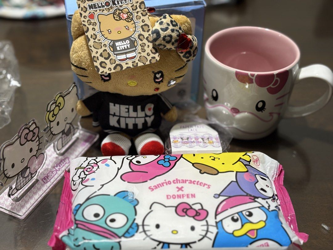 Hello Kitty Plush, Mug, Acrylic Stands & More Bundle (Category: Character Goods) located in Manila. Submitted by hklylovez (Listing ID 1464461972, Image 1). Description: - Adorable Kitty plush toy with stylish leopard print accents and ' Kitty' shirt. - Comes with a matching mug featuring a cute Kitty face design. - Includes two clear acrylic Kitty figures for display. - Also includes a pack of Sanrio characters wet wipes. - All items are authent