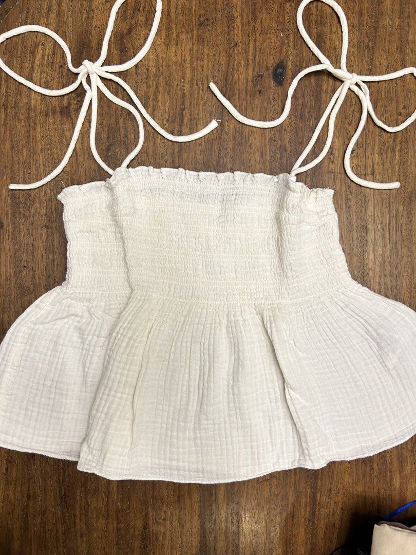 H&M White Top (Category: Sleeveless) located in Manila. Submitted by tshopph (Listing ID 1464396530, Image 1). Description: H&M White Textured Cotton Tie-Shoulder Babydoll Top Features a stretchy smocked bodice and self-tie shoulder straps that give it a dainty, cottagecore/boho vibe. Perfect for beach trips, casual days out, or summer dates! 🌿🌞☁️ Condition: lightly used Size: EUR/US Medium Price: ₱500, negotiable Same-day delivery via Lalamove
