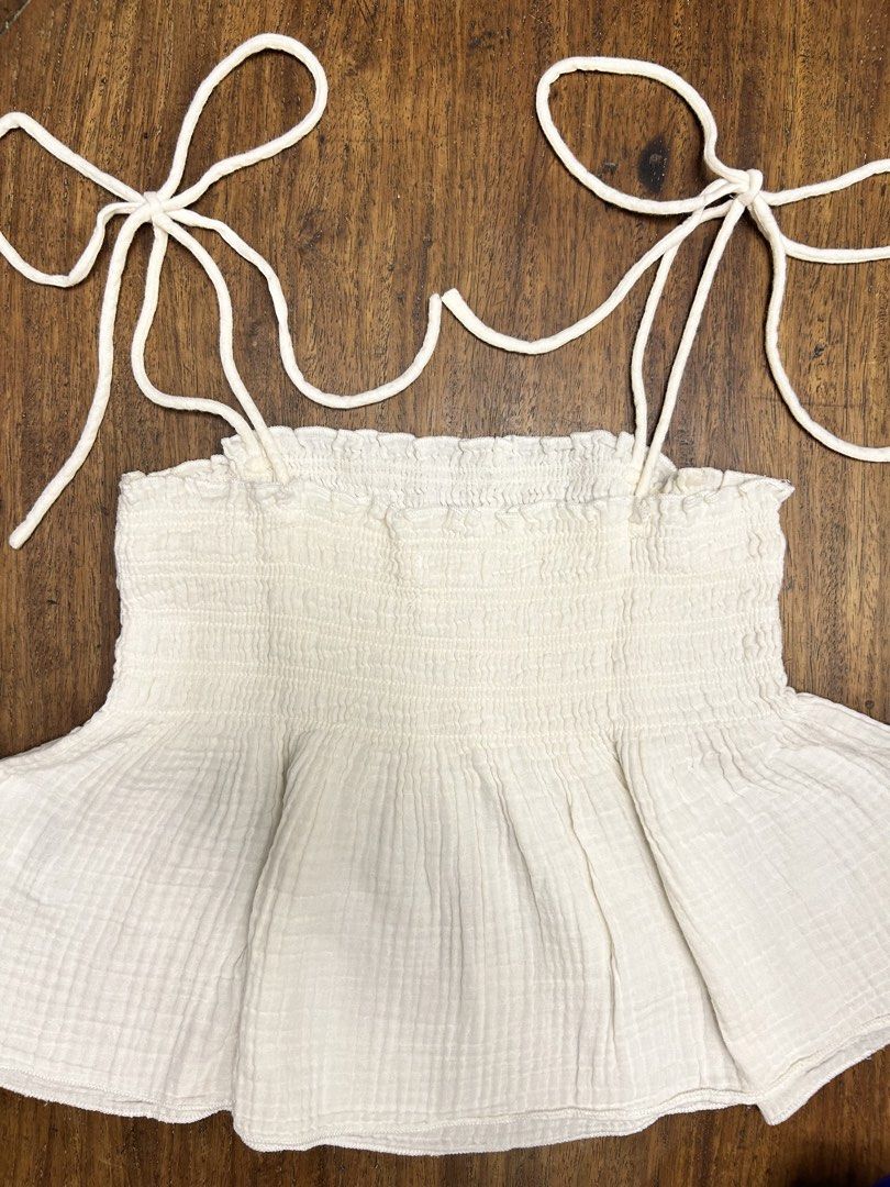 H&M White Top (Category: Sleeveless) located in Manila. Submitted by tshopph (Listing ID 1464396530, Image 2). Description: H&M White Textured Cotton Tie-Shoulder Babydoll Top Features a stretchy smocked bodice and self-tie shoulder straps that give it a dainty, cottagecore/boho vibe. Perfect for beach trips, casual days out, or summer dates! 🌿🌞☁️ Condition: lightly used Size: EUR/US Medium Price: ₱500, negotiable Same-day delivery via Lalamove