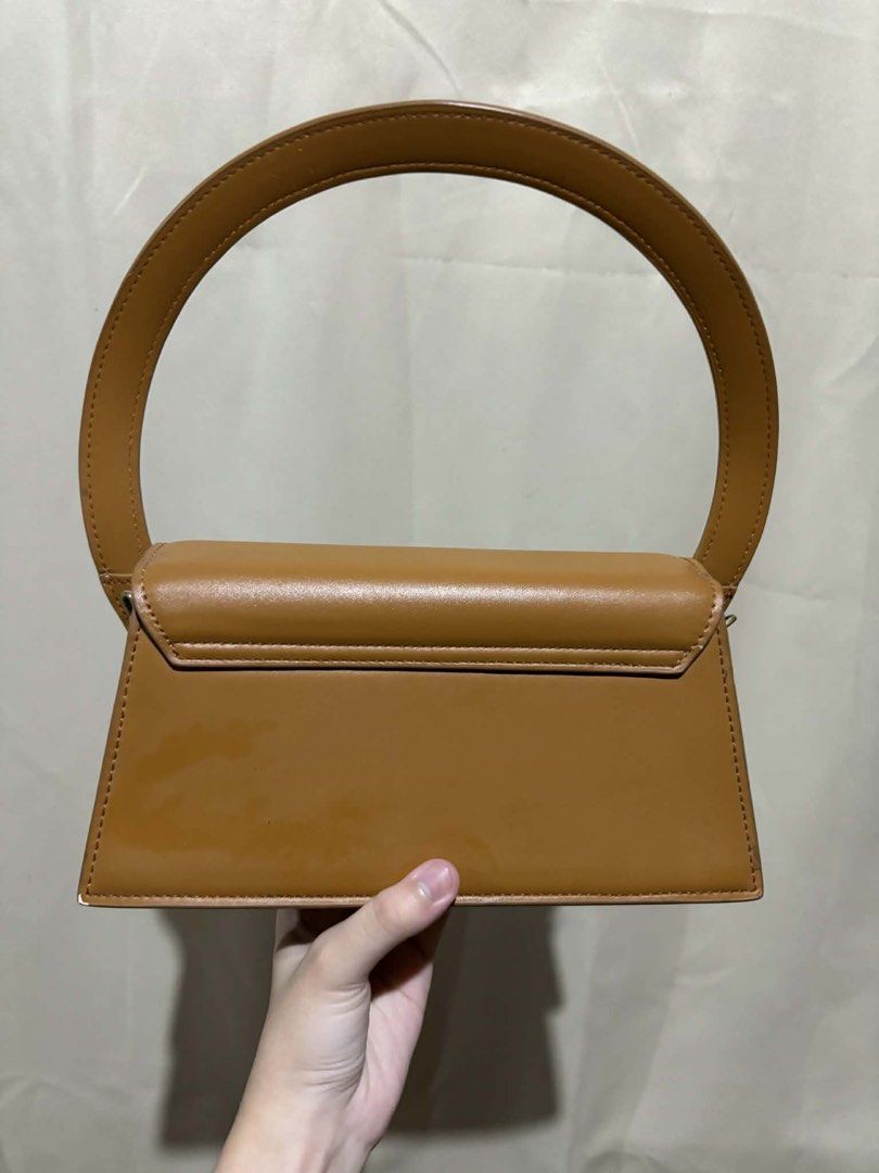 Jacquemus Brown Top Handle Bag (Category: Shoulder Bags) located in Nagcarlan. Submitted by fiercewater-40fb (Listing ID 1464418543, Image 2). Description: - Cute brown top handle bag - Simple and chic design - Rounded handle shape - Faux leather material - Rectangular shape with flap closure - Versatile for everyday use or night out.