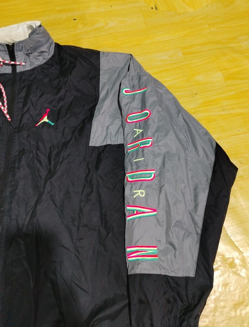 Jordan Windbreaker Jacket XL (Category: Coats, Jackets and Outerwear) located in Lucena. Submitted by thrifteditem (Listing ID 1464384801, Image 2). Description: - Vintage Jordan windbreaker jacket - Colorway: Black, grey, and white - Features: Jumpman logo and 'Jordan' text on sleeve - Design details: Drawstring hood, elastic cuffs - Origin: Made in Vietnam - Size: XL.