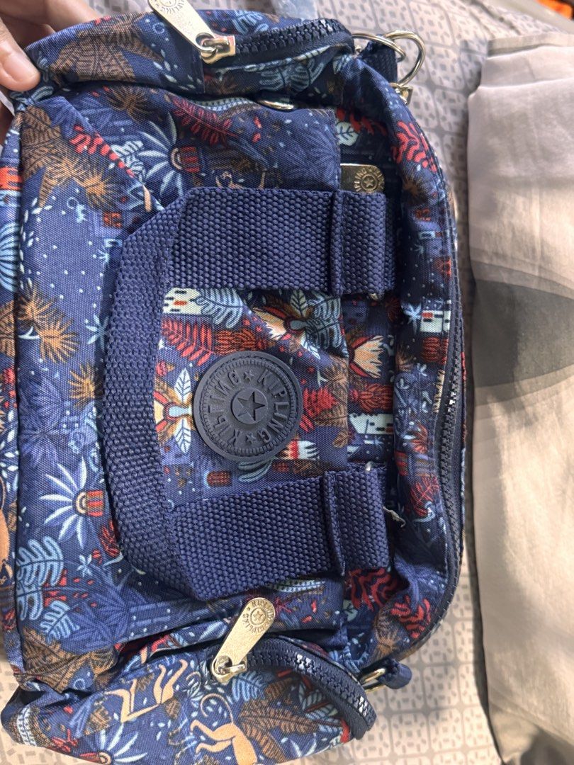 Kipling Monkey Bag Charm with Blue Floral Kipling Bag (Category: Purses & Pouches) located in Obando. Submitted by Wintermelonzzzz (Listing ID 1464378736, Image 1). Description: - Classic Kipling bag with a charming blue floral print. - Features the iconic Kipling monkey charm. - Stylish gold-toned zippers. - Interior lining with a fun polka dot pattern. - Ideal addition to any Kipling collection or a thoughtful gift..