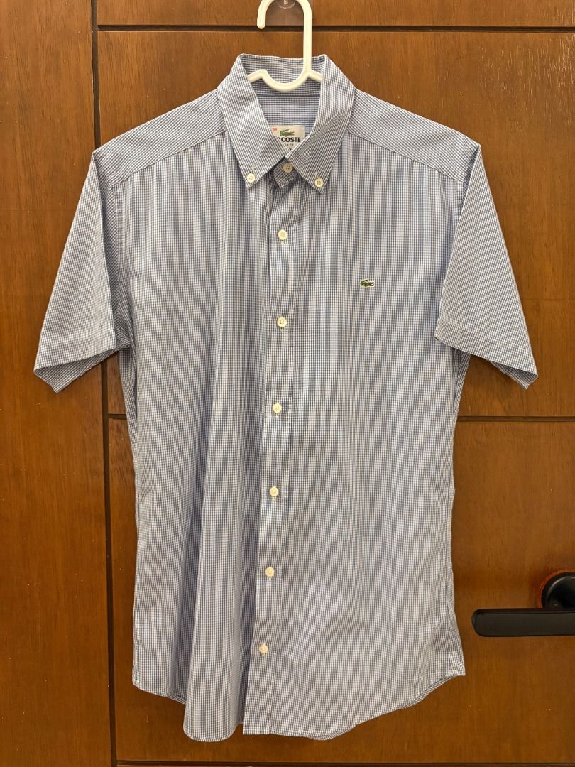 Lacoste Blue/White Micro-Check Short Sleeve Button-Down Shirt (Category: Tshirts & Polo Shirts ) located in Mandaluyong City. Submitted by jbor88 (Listing ID 1464366957, Image 1). Description: Brand: Lacoste Color: Blue and White Gingham Style: Short Sleeve Shirt Fit: Slim Fit Collar: Button-Down Features: Signature crocodile logo on chest Slim Fit 38 W=46cm L=70cm.