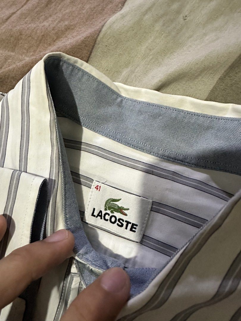 Lacoste Striped Button-Up Shirt Size 41 (Category: Tshirts & Polo Shirts ) located in Quezon City. Submitted by jeconiah.tayuman (Listing ID 1464549168, Image 3). Description: - Classic Lacoste button-up shirt - Color: White with thin blue stripes - Size: 41 (23x30) - Features a chest pocket - Ideal for smart casual outfits - Selling as it's no longer needed.