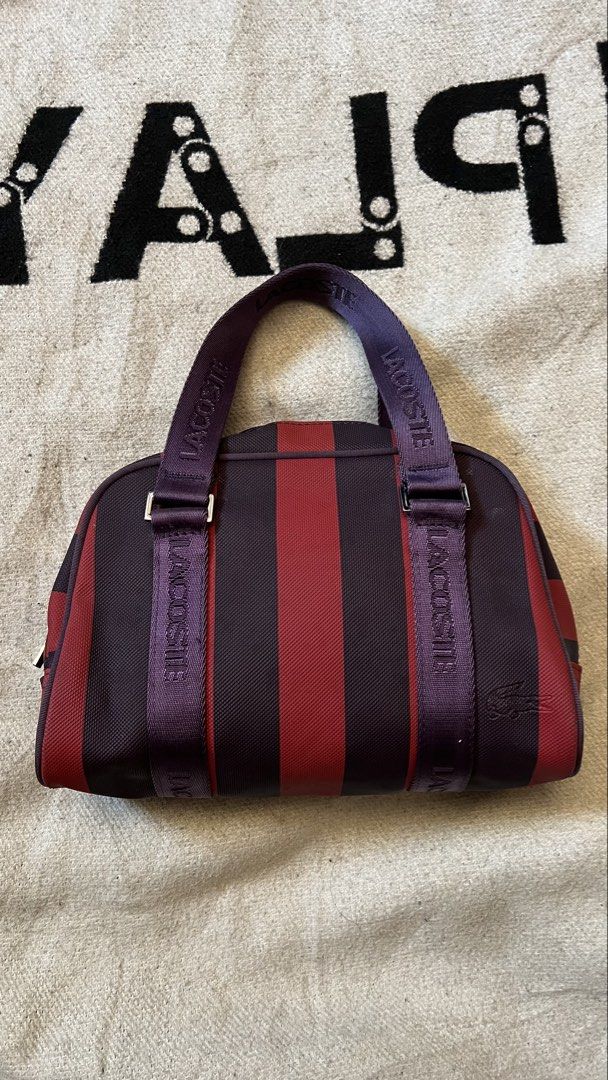Lacoste Striped Duffle Bag (Category: Sling Bags) located in Cagayan de Oro. Submitted by nelsondel21723 (Listing ID 1464390550, Image 1). Description: - Stylish Lacoste duffle bag - Eye-catching red and purple stripe design - 'LACOSTE' branded straps - Secure zipper closure with branded pulls - Interior clip for keys or small pouch - Ideal for gym sessions or short trips.