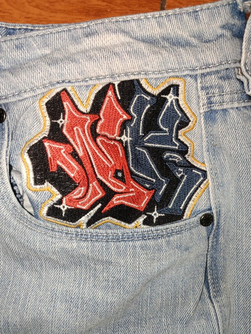Light Wash Embroidered Denim Jeans (Category: Jeans) located in Manila. Submitted by grimjoww09 (Listing ID 1464355732, Image 3). Description: - Light wash denim jeans - Unique embroidery: Dragon and skull design on back pockets - Graffiti-style patch on front pocket - Relaxed fit - Ideal for casual wear.