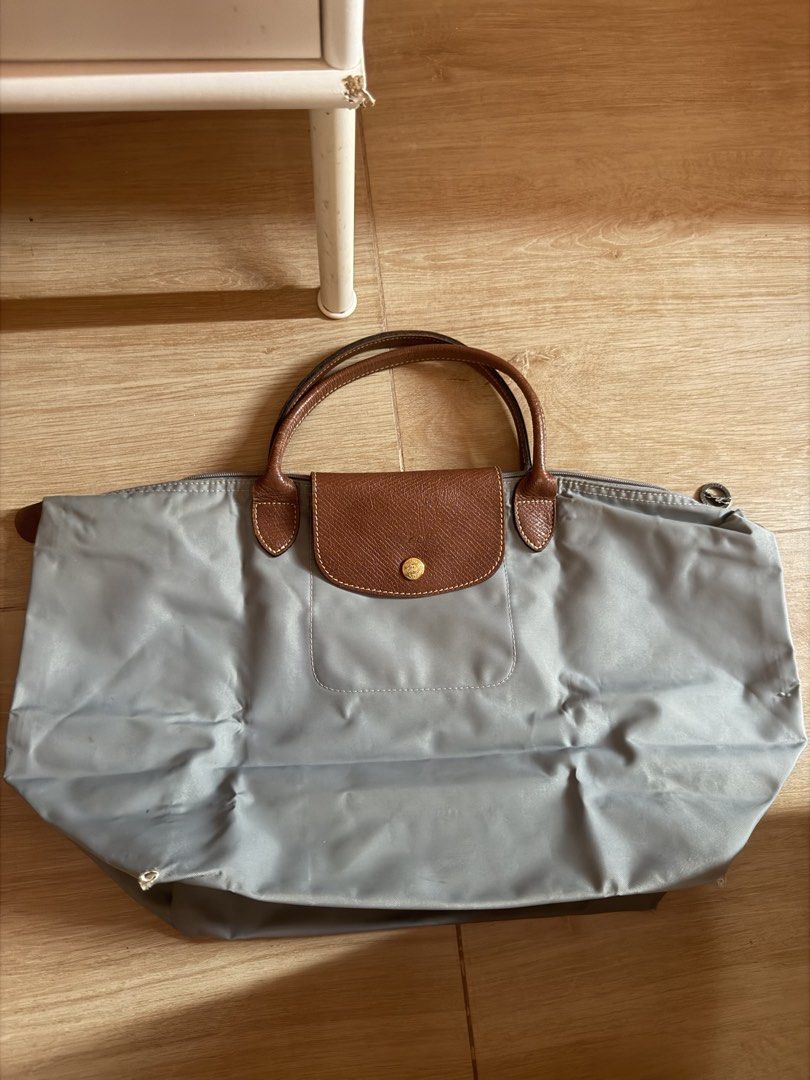 Longchamp Le Pliage Tote Bag Grey (Category: Luxury Bags & Wallets) located in Santa Rosa. Submitted by decluttering_. (Listing ID 1464363104, Image 1). Description: - Classic Longchamp tote bag - Grey nylon with brown leather handles and trim - Zips closed for security - Spacious interior for essentials - Ideal for work or travel - Note: Some marks and wear on the interior lining.
