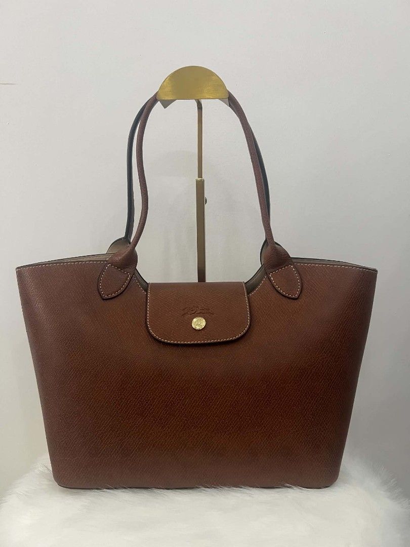 Longchamp Tote Bag (Category: Luxury Bags & Wallets) located in Paoay. Submitted by rvf1230 (Listing ID 1464397063, Image 2). Description: - Classic Longchamp tote bag - Rich brown color - Durable leather with embossed horse logo - Snap closure - Comfortable shoulder straps - Spacious interior for daily essentials - Timeless wardrobe piece.