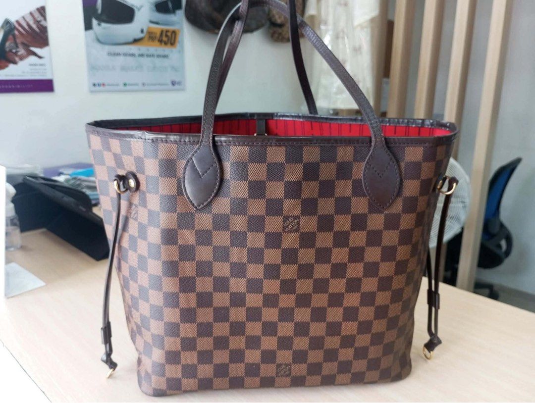 Louis Vuitton Neverfull Damier Ebene Tote Bag (Category: Luxury Bags & Wallets) located in Quezon City. Submitted by christelleannesy (Listing ID 1464481016, Image 1). Description: - Classic Louis Vuitton Neverfull tote - Damier Ebene canvas with striking red interior - Ample space for all your essentials - Includes an interior zippered pocket and D-ring - Durable leather straps - Adjustable drawstring sides for customized capacity - Ideal everyd