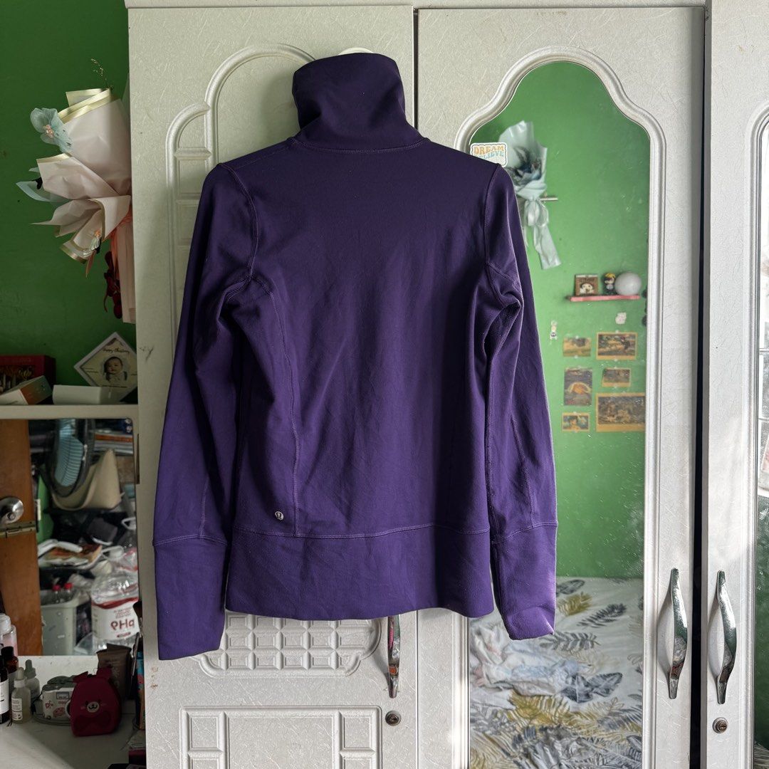 Lululemon Purple Full Zip Jacket with Thumbholes (Category: Coats, Jackets and Outerwear) located in Manila. Submitted by zennyaur (Listing ID 1464426503, Image 2). Description: Purple Lululemon jacket. Full zip closure with a high neck. Has thumbholes on the sleeves for extra warmth. Two zip pockets on the front. Great for workouts or casual wear. Shows the Lululemon logo on the back..
