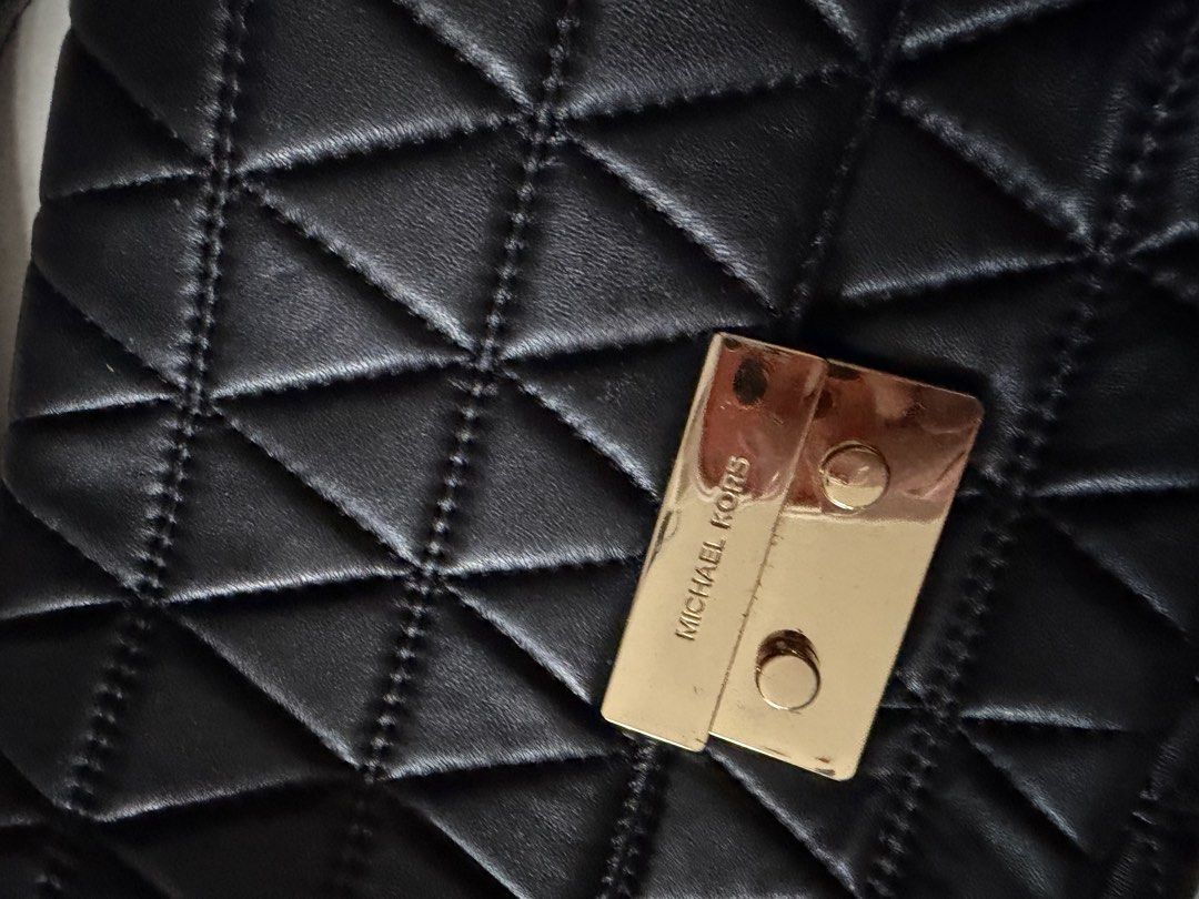 Michael Kors Black Quilted Leather Chain Shoulder Bag (Category: Looking For) located in Santa Rosa. Submitted by decluttering_. (Listing ID 1464568281, Image 2). Description: - Michael Kors black quilted leather shoulder bag - Features a gold chain strap - Iconic Michael Kors logo on the front clasp - Spacious interior, perfect for essentials - Versatile for nights out or everyday use - Please note: shows some signs of wear on leather and hardwa