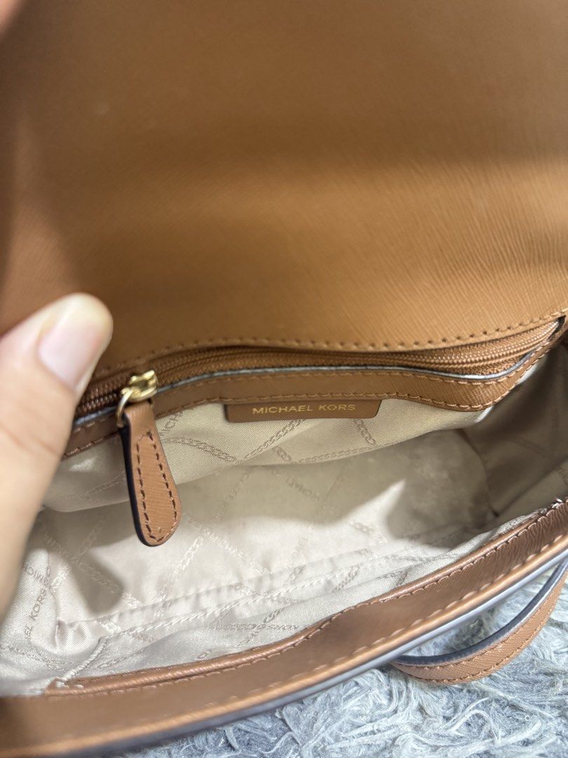 Michael Kors Brown Leather Top Handle Bag (Category: Luxury Bags & Wallets) located in Batangas. Submitted by bagsbyann (Listing ID 1464361545, Image 3). Description: - Authentic Michael Kors handbag in a stylish brown hue. - Crafted from durable Saffiano leather with elegant gold hardware. - Versatile carrying options: comfortable top handle and a detachable shoulder strap. - Interior features a secure zip pocket and convenient slip pockets for 