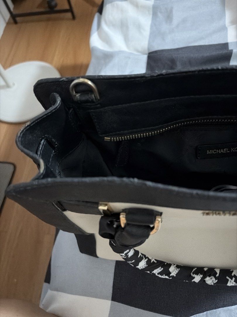 Michael Kors Saffiano Dillon Satchel (Category: Luxury Bags & Wallets) located in Paranaque City. Submitted by thisisbuttercup (Listing ID 1464541676, Image 3). Description: - Michael Kors satchel bag - Stylish two-tone beige and black design - Elegant gold hardware details - Functional interior with zip pocket and compartments - Comfortable top handles with a decorative scarf tie - Includes a replaced detachable shoulder strap for versatile wear