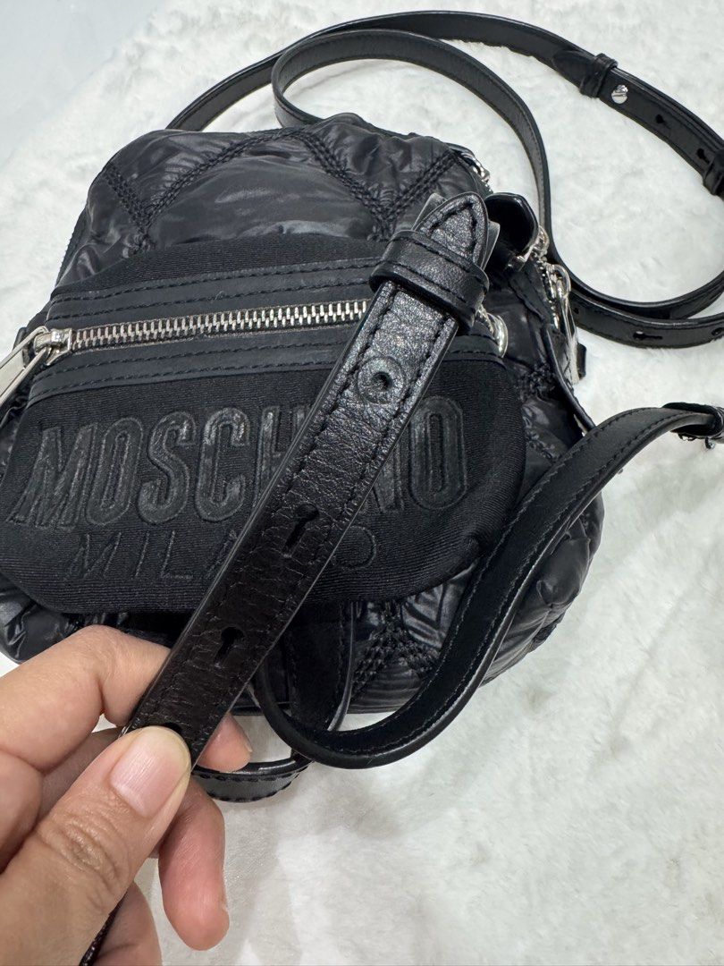 Moschino Milano Quilted Multi Way Bag (Category: Luxury Bags & Wallets) located in San Nicolas. Submitted by ihascat (Listing ID 1464498851, Image 2). Description: - Black quilted Moschino crossbody bag - Flaws: Missing adjustment stud hut still functional -can be shoulder bag or backpack - Iconic Moschino Milano logo on front - Adjustable leather strap - Silver-tone hardware and zipper details - Versatile for everyday or evening use.