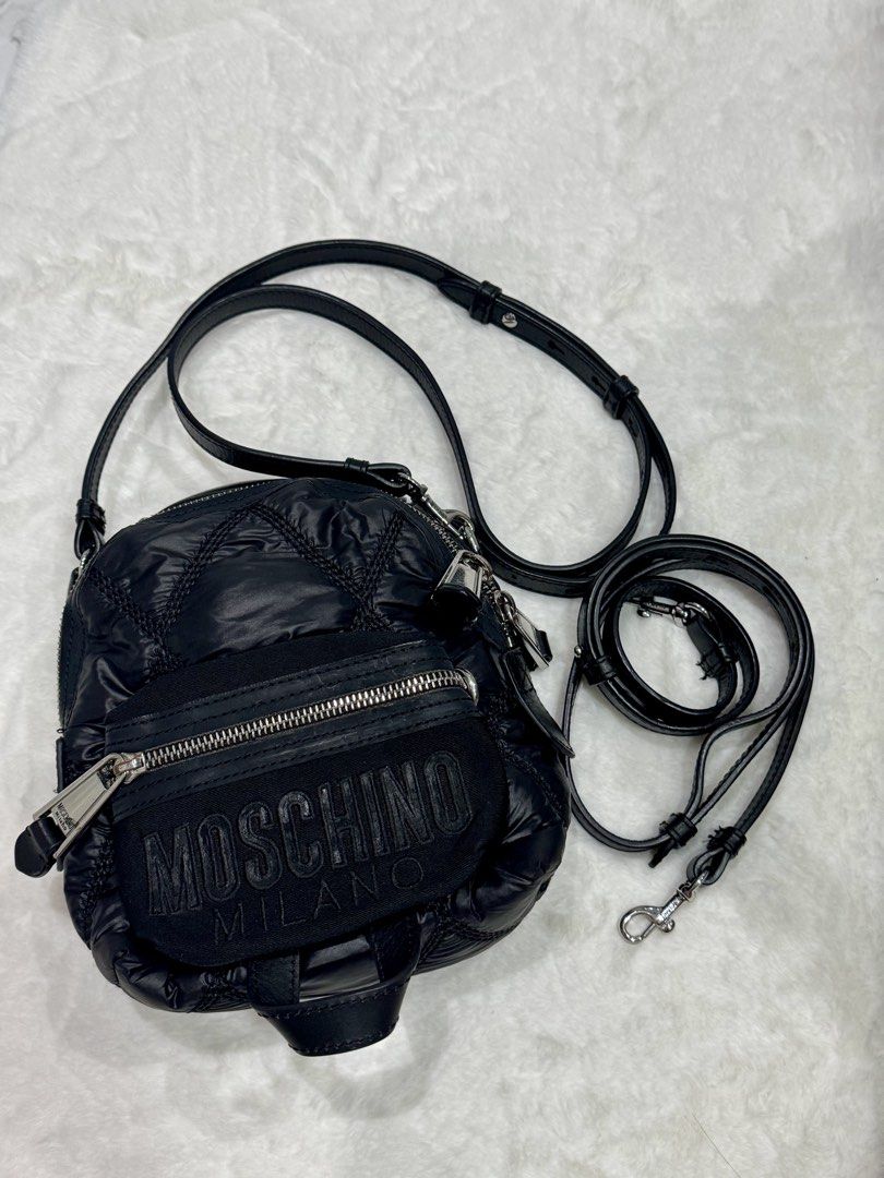 Moschino Milano Quilted Multi Way Bag (Category: Luxury Bags & Wallets) located in San Nicolas. Submitted by ihascat (Listing ID 1464498851, Image 1). Description: - Black quilted Moschino crossbody bag - Flaws: Missing adjustment stud hut still functional -can be shoulder bag or backpack - Iconic Moschino Milano logo on front - Adjustable leather strap - Silver-tone hardware and zipper details - Versatile for everyday or evening use.
