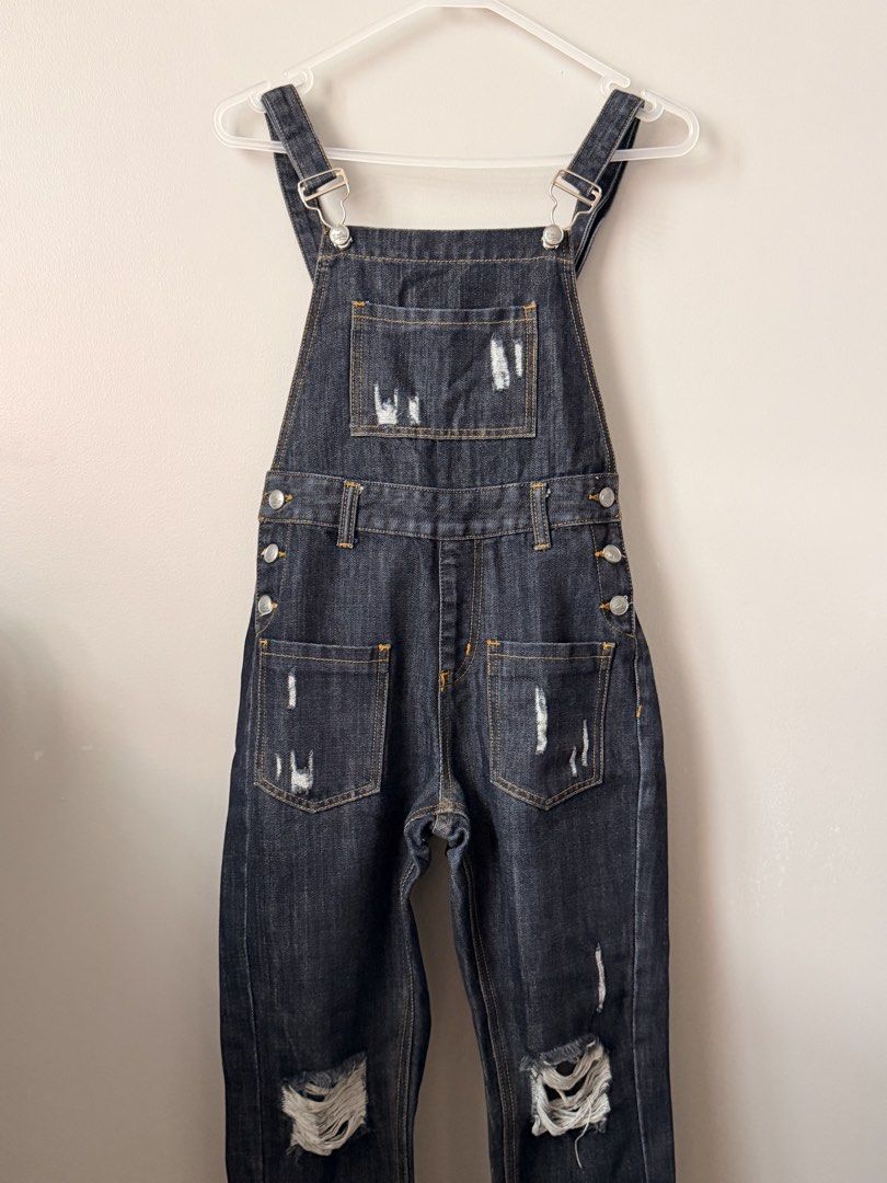 Mossimo Distressed Dark Wash Denim Overalls (Category: Jumpsuits) located in Quezon City. Submitted by ninny.ph (Listing ID 1464389815, Image 2). Description: - Dark wash denim overalls - Distressed detailing on front pocket, back pockets, and knees - Adjustable straps with button closures on sides - Classic five-pocket styling - Perfect for a casual, edgy vibe.