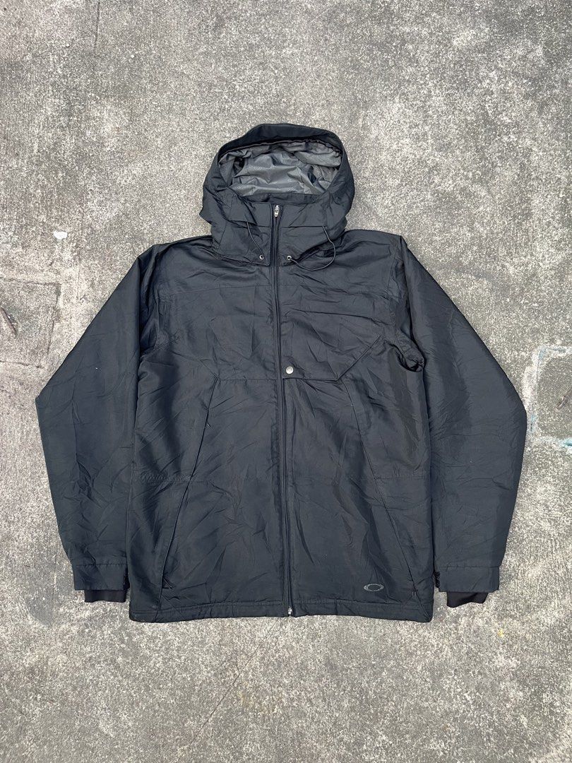 Oakley Ski/Snowboard Jacket (Category: Coats, Jackets and Outerwear) located in Pilar. Submitted by fast-flip-ni-miko. (Listing ID 1464442262, Image 1). Description: - Black Oakley hooded jacket - Full zip closure - Multiple front and inside pockets - Adjustable drawstring on hood - Ideal for outdoor activities - Features visible Oakley branding - Ready for your next adventure.