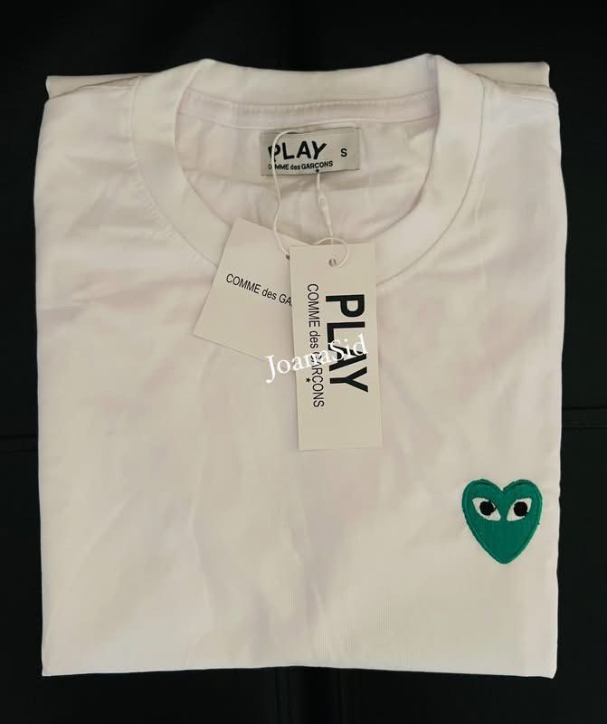 PLAY COMME des GARÇONS White T-shirt (Category: Shirts) located in Lingayen. Submitted by jjsid (Listing ID 1464514405, Image 1). Description: - Brand new PLAY COMME des GARÇONS white t-shirt - Features the iconic green heart logo - 100% Cotton, made in Vietnam - Size: S on tag (fits until semi-large since big po ang sizing nito) - Measurements: Pit to pit approx. 19 inches, length approx. 26 inches - Comes with original tags ✨measurements are pr