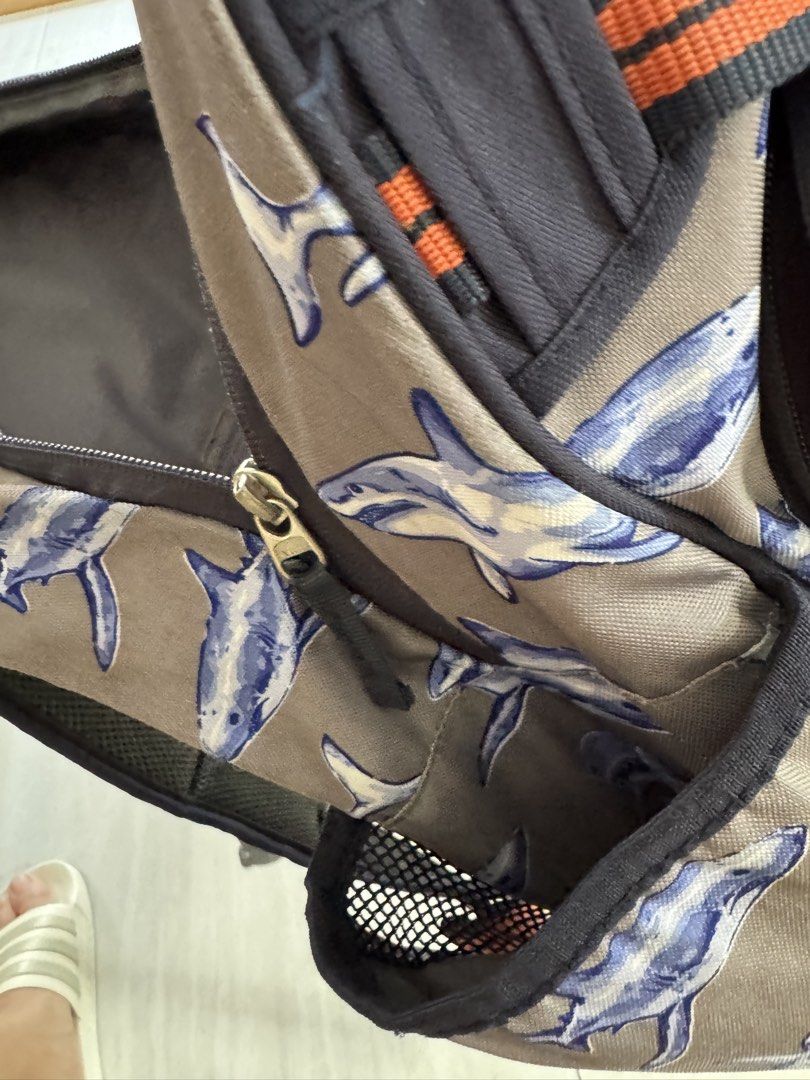 Pottery Barn Kids Shark Print Backpack (Category: Babies & Kids Fashion) located in Makati City. Submitted by kdl123 (Listing ID 1464368065, Image 3). Description: - Fun grey backpack with a playful shark print. - Navy blue base and straps for a classic look. - Accented with orange and navy stripes. - Convenient mesh side pockets for water bottles. - Padded back and shoulder straps ensure comfort. - All zippers are in good working condition. - Id