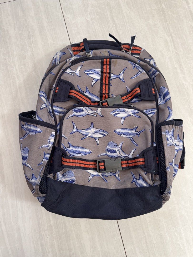 Pottery Barn Kids Shark Print Backpack (Category: Babies & Kids Fashion) located in Makati City. Submitted by kdl123 (Listing ID 1464368065, Image 1). Description: - Fun grey backpack with a playful shark print. - Navy blue base and straps for a classic look. - Accented with orange and navy stripes. - Convenient mesh side pockets for water bottles. - Padded back and shoulder straps ensure comfort. - All zippers are in good working condition. - Id