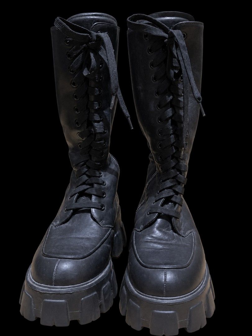 Prada Black Leather Lace-Up Chunky Platform Boots (Category: Boots) located in Manila. Submitted by dizonnixni94357 (Listing ID 1464472303, Image 1). Description: - Genuine black leather Prada boots - Knee-high design - Lace-up front and side zipper for adjustable fit - Chunky platform sole for added height and style - Authentic Made in Italy craftsmanship - Ideal for creating a statement outfit.