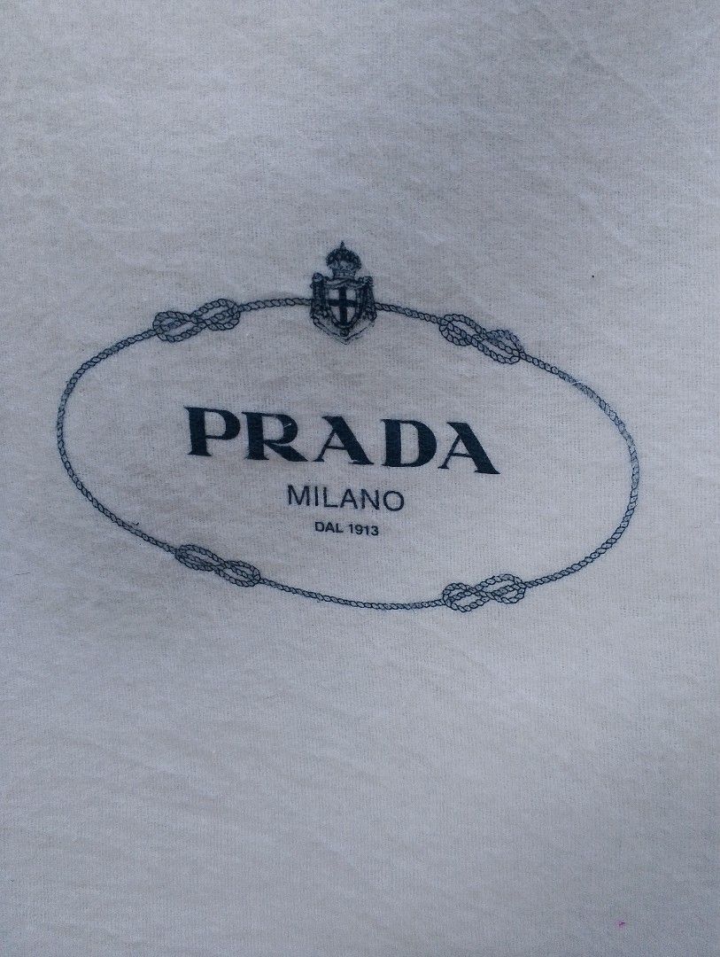 PRADA MILANO AUTHENTIC DUST BAG / STORAGE BAG (Category: Luxury Bags & Wallets) located in Baliuag. Submitted by retrovault83 (Listing ID 1464380267, Image 2). Description: ✨ Condition: 9.5–10/10 – Excellent Preloved Condition 📏 Measurements (Flat Lay): Width: 21.5 Length: 18 ✅ Condition Notes: • Crisp white 100% cotton material • Classic Prada Milano printed crest logo centered on front • Complete with interior tag (Code: 130772) • Made in Ital