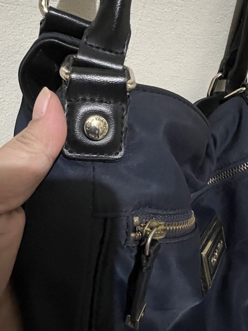 Preloved Calvin Klein hobo nylon bag (Category: Luxury Bags & Wallets) located in Makati City. Submitted by transactwithme (Listing ID 1464466143, Image 3). Description: Preloved Calvin Klein shoulder bag Not abused, hardwares can be seen a slight changesi in color but overall still in very good condition Color: navy blue Material: nylon Size H 28 L 35 W 12 .