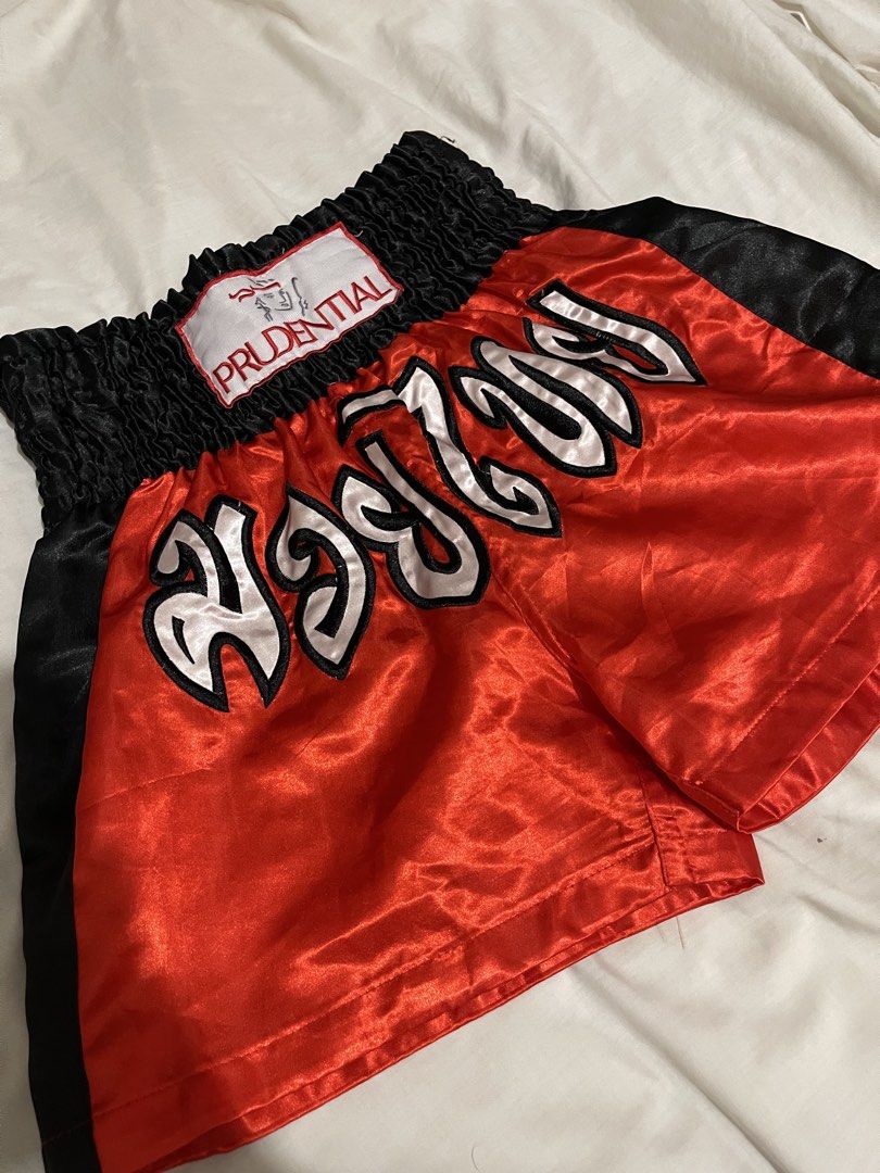 Prudential Muay Thai Boxing Shorts Red Black (Category: Shorts) located in Makati City. Submitted by afterpiece (Listing ID 1464481399, Image 2). Description: Red and black Muay Thai shorts with elastic waistband and Thai writing. Perfect for training. fits 26-30, exact measurements on photos. issue: small loose threads on some parts, you can remove it with a lighter..
