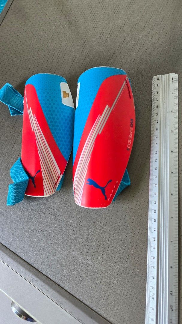Puma EvoSpeed Soccer Shin Guards (Category: Racket and Ball Sports) located in Pasig City. Submitted by acerrace (Listing ID 1464374063, Image 1). Description: - Puma EvoSpeed shin guards - Red and blue design with white stripes - Features elastic straps for a secure fit - Ideal for soccer practice and games - Ready for a new owner.