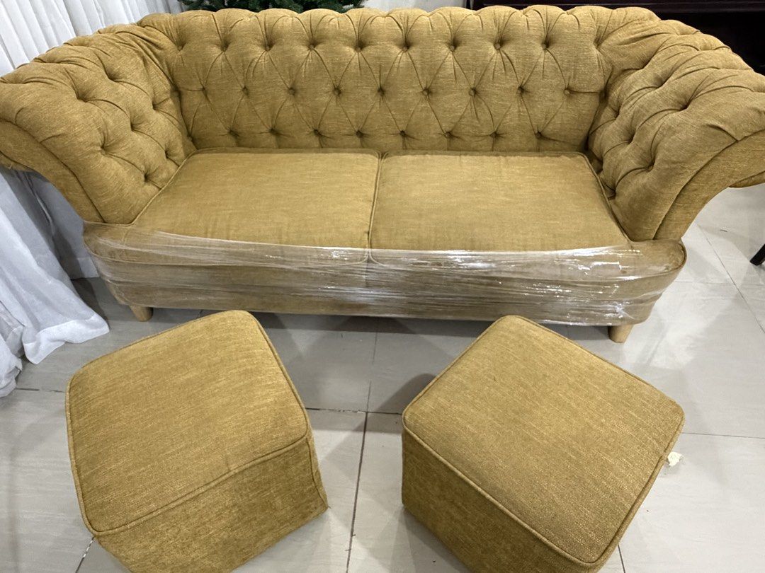Relax Form Tufted Chesterfield Sofa with 2 Ottomans (Category: Sofas) located in Pakil. Submitted by abeverage (Listing ID 1464466598, Image 1). Description: - Relax Form Chesterfield Sofa Set - Includes two matching square ottomans - Deep button tufting and elegant rolled arms - Upholstered in a textured mustard yellow fabric - Sofa is wrapped in protective plastic - Ideal for living rooms or lounge areas.