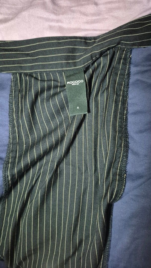 ROCOCO Pinstripe Wrap Midi Skirt with Pockets (Category: Jeans) located in Manila. Submitted by liv31_ (Listing ID 1464472949, Image 1). Description: ROCOCO Pinstripe Wrap Midi Skirt with Pockets ​Has discreet, deep side pockets. ​ Classic fine vertical pinstripes on dark charcoal/forest-tone fabric, contrasted with a smooth solid blue/slate underlay. ​ Ideal for workwear, smart casual, or academia-inspired styling. .