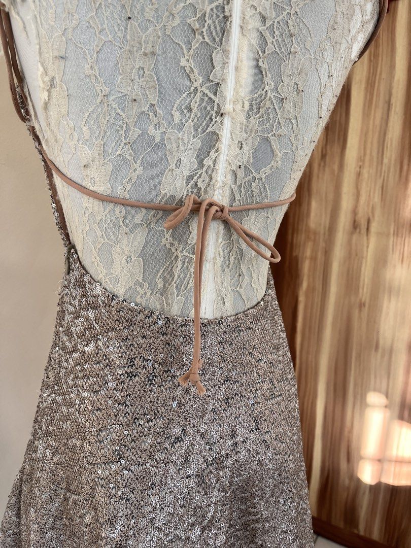 Sequin backless mini dress (Category: Dresses) located in San Jose. Submitted by thymies (Listing ID 1464515748, Image 3). Description: Fabric & Finish: Covered in champagne/rose-gold sequins, giving it a high-shine, textured look. Silhouettte & Length: A-line or subtle shift silhouette hitting above the knee (mini length). Neckline: Scoop neckline with delicate spaghetti straps. Back Detail: Open back (backless design) with crisscross or tie-up 