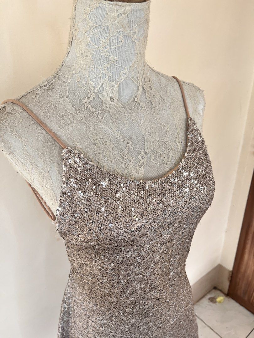 Sequin backless mini dress (Category: Dresses) located in San Jose. Submitted by thymies (Listing ID 1464515748, Image 2). Description: Fabric & Finish: Covered in champagne/rose-gold sequins, giving it a high-shine, textured look. Silhouettte & Length: A-line or subtle shift silhouette hitting above the knee (mini length). Neckline: Scoop neckline with delicate spaghetti straps. Back Detail: Open back (backless design) with crisscross or tie-up 