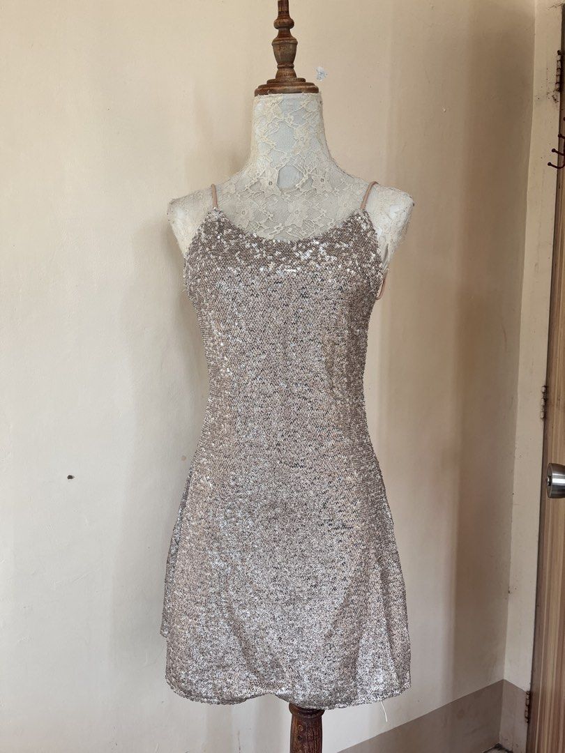 Sequin backless mini dress (Category: Dresses) located in San Jose. Submitted by thymies (Listing ID 1464515748, Image 1). Description: Fabric & Finish: Covered in champagne/rose-gold sequins, giving it a high-shine, textured look. Silhouettte & Length: A-line or subtle shift silhouette hitting above the knee (mini length). Neckline: Scoop neckline with delicate spaghetti straps. Back Detail: Open back (backless design) with crisscross or tie-up 