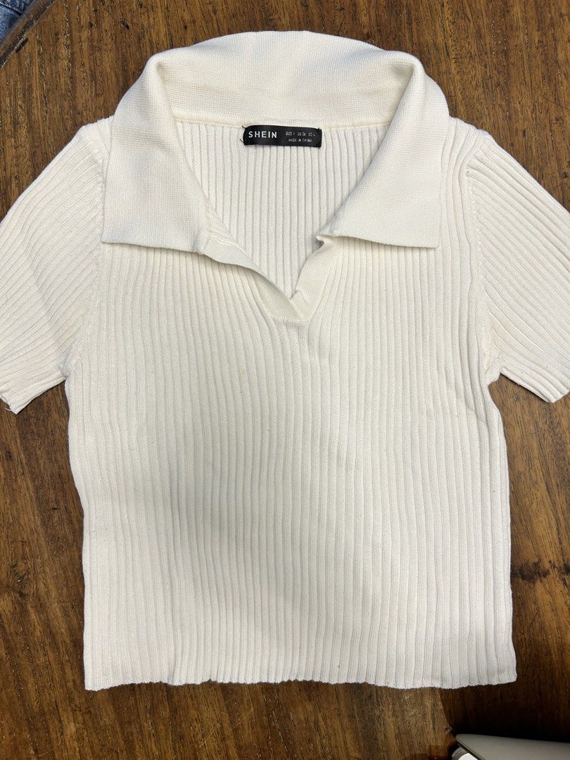 SHEIN White V-Neck Knit Top (Category: Shirts) located in Antipolo. Submitted by tshopph (Listing ID 1464476998, Image 1). Description: Shein White Ribbed Collar Knit Top A chic, preppy basic that pairs effortlessly with high-waisted trousers, skirts, or jeans. Features a soft ribbed knit material with a classic open polo collar for an elevated, clean look. ✨ Style: Open Polo Collar / V-Neckline / Short Sleeve / Ribbed Knit ✨ Material: Ribbed Kni