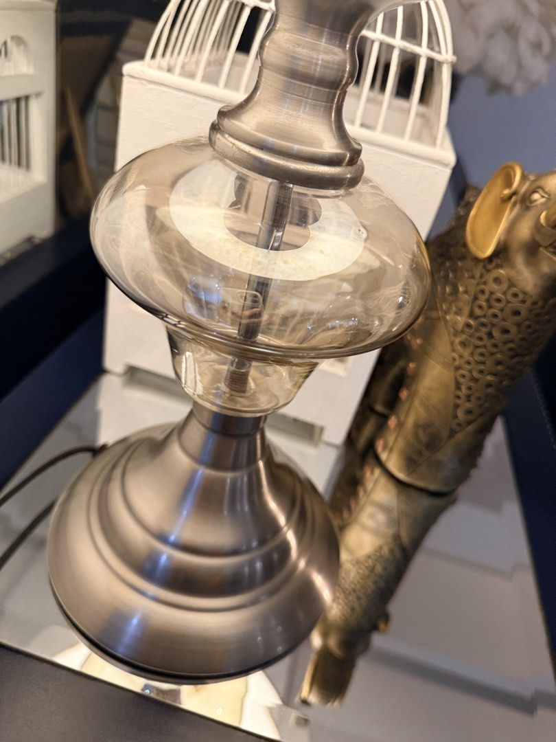 Silver and Glass Table Lamp with Beige Shade (Category: Lighting) located in Quezon City. Submitted by yourheaduhunter (Listing ID 1464472872, Image 2). Description: Beat price posted - Brushed silver base - Clear glass middle section - Textured beige linen shade - Ideal size for side table or nightstand - Provides a warm, inviting glow - In excellent working condition 54cm height 25-30cm shade diameter.