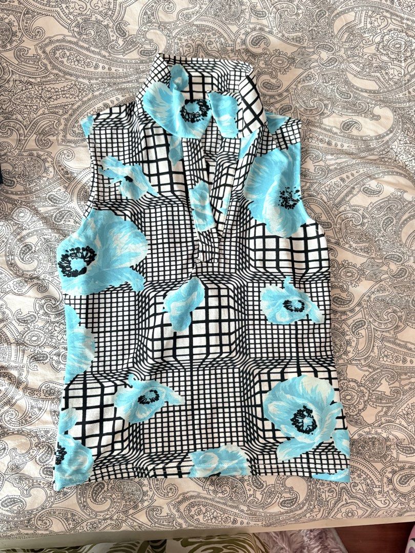 Sleeveless Top with Blue Floral and Grid Pattern (Category: Sleeveless) located in Cainta. Submitted by kitkatoli (Listing ID 1464364232, Image 1). Description: - Sleeveless top - Unique blue floral and black grid pattern - Collared neckline - Buttons down the front - Fabric has stretch - Perfect for a statement look.