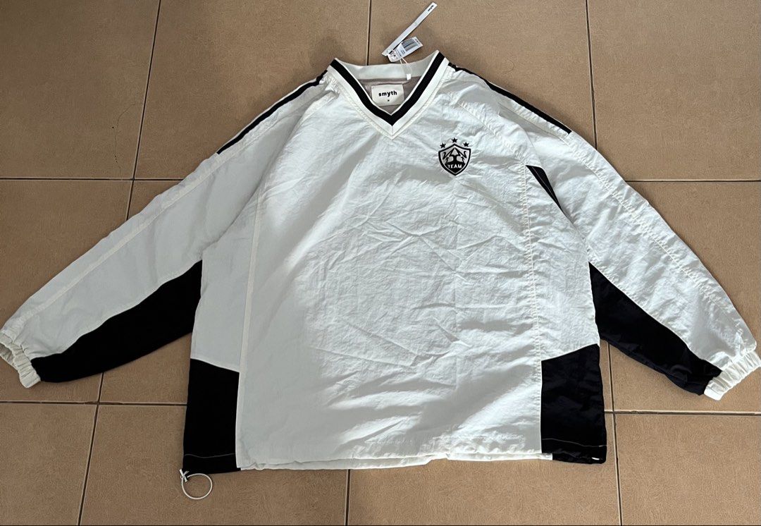 Smyth Off-White Medium V-Neck Track Jacket (Category: Coats, Jackets and Outerwear) located in Manila. Submitted by ali.preloved (Listing ID 1464529027, Image 1). Description: - Smyth track jacket - Color: Off-white and black - Size: Medium (23 L x 28 W) - V-neck design - Elasticated cuffs and hem - Small crest logo on chest - Original tag still attached - Purchased from SM Store.