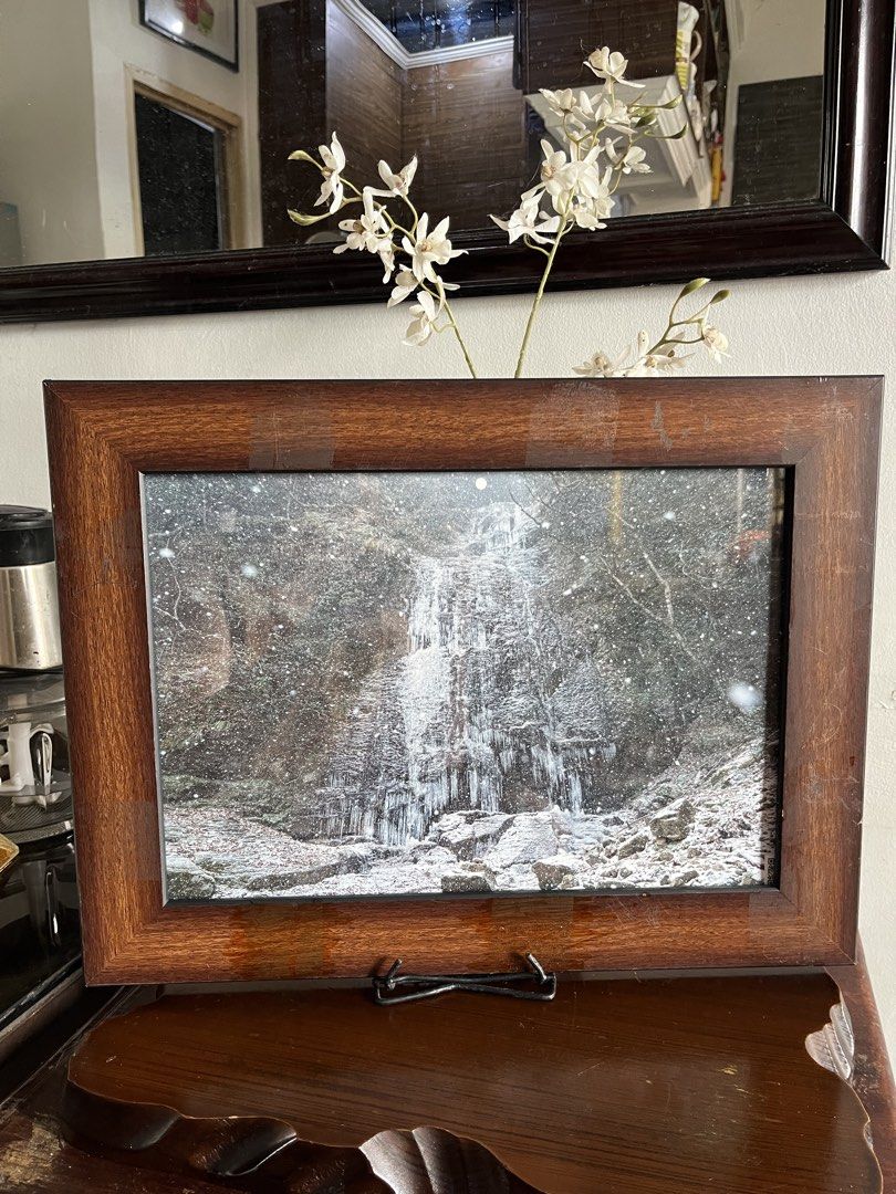 Solid wood Frame. ,Winter Waterfall Photo (Category: Frames & Pictures) located in Taguig. Submitted by minmin_parker (Listing ID 1464371970, Image 1). Description: - Stunning wooden framed photo of a frozen waterfall. - Captures a serene winter scene with falling snow. - Features a premium dark wood frame with a rich finish. - Ideal for enhancing your home decor. - Versatile display options: ready to hang or use with a stand..