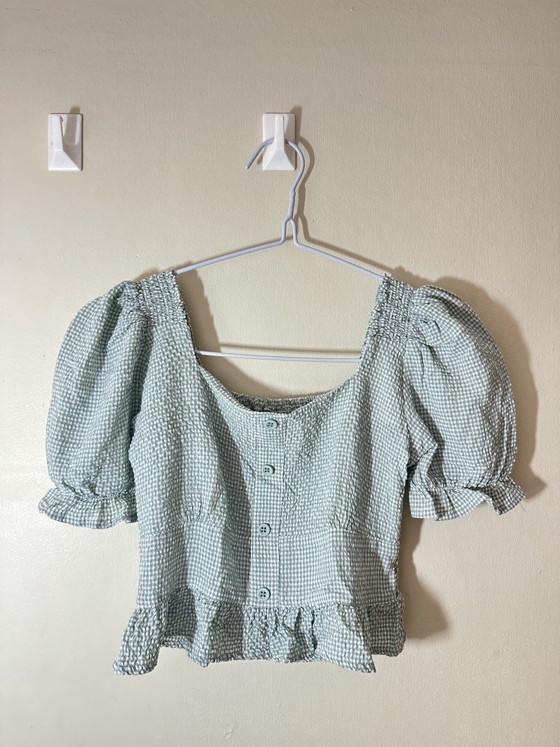 JUST G Square Neck Gingham Puff Sleeve Top (Category: Blouses) located in Baguio. Submitted by archivedbyj (Listing ID 1464390572, Image 1). Description: - Adorable gingham pattern - Trendy puff sleeves - Flattering square neckline - Functional button-front closure - Feminine ruffled hem and sleeves - Textured fabric for added detail - Versatile for casual outings or dressing up.
