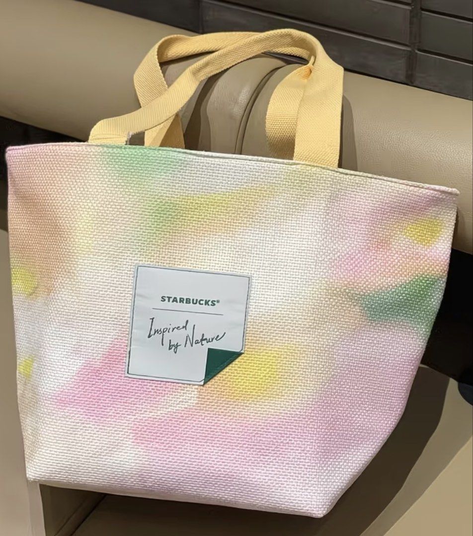 Starbucks Nature Tote Bag (Category: Tote Bags) located in Manila. Submitted by shayne2 (Listing ID 1464427544, Image 1). Description: - Adorable pastel tie-dye Starbucks tote bag - Features light yellow handles - Ideal for everyday use or as a small travel bag - Lightweight and easy to carry - A unique Starbucks accessory to grab!.