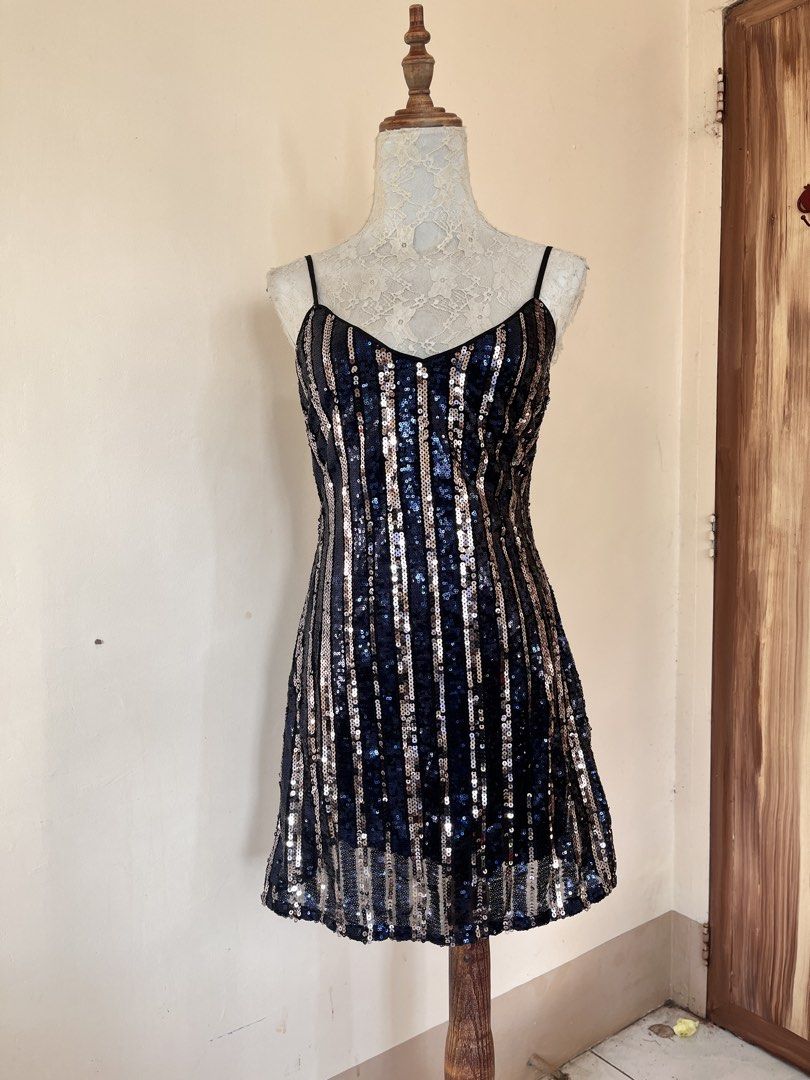 Striped sequin cami mini dress (Category: Dresses) located in San Jose. Submitted by thymies (Listing ID 1464516918, Image 1). Description: Pattern & Fabric: Alternating vertical stripes of dark navy/black sequins and gold sequins set over a sheer mesh base. Silhouette & Length: Short, bodycon to slight A-line silhouette ending above the knee. Neckline & Straps: Gentle V-neckline with adjustable dark cami/spaghetti straps. Closure: Hidden back zi