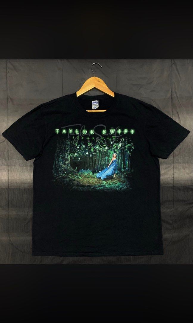 Taylor Swift Speak Now Shirt (Category: Tshirts & Polo Shirts ) located in Batangas. Submitted by Treasure.vtg (Listing ID 1464478896, Image 1). Description: - Black t-shirt featuring Taylor Swift's Folklore album graphic. - Front design: Album art with Taylor in a blue dress in a forest. - Back design: Green graphic of hands with song titles. - Ideal for any Taylor Swift fan (Swiftie)!.