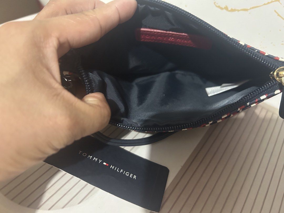 Tommy Hilfiger Wristlet Pouch Red White Blue Geometric Pattern (Category: Purses & Pouches) located in Manila. Submitted by trendsby_t (Listing ID 1464539176, Image 2). Description: - Authentic Tommy Hilfiger wristlet pouch - Stylish geometric pattern in red, white, and blue - Convenient wrist strap for easy carrying - Secure zip closure - Classic navy blue interior - Brand new with original tag attached - Ideal for keeping your essentials organi