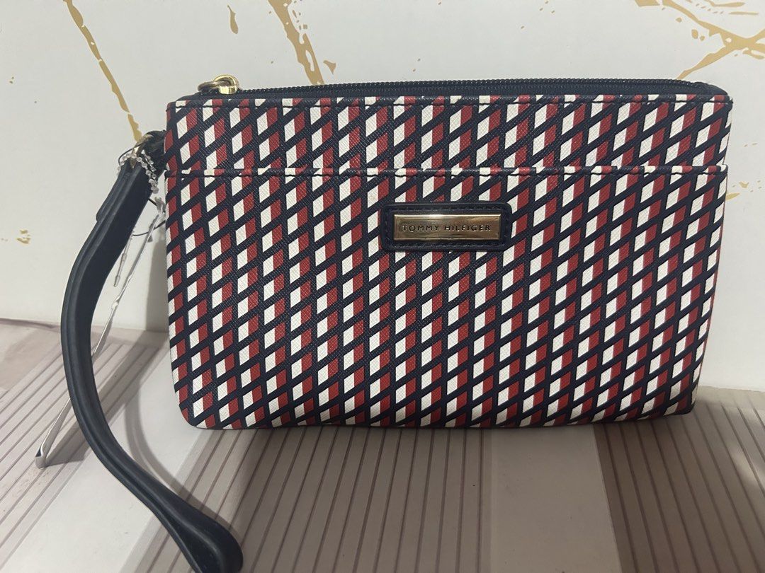 Tommy Hilfiger Wristlet Pouch Red White Blue Geometric Pattern (Category: Purses & Pouches) located in Manila. Submitted by trendsby_t (Listing ID 1464539176, Image 1). Description: - Authentic Tommy Hilfiger wristlet pouch - Stylish geometric pattern in red, white, and blue - Convenient wrist strap for easy carrying - Secure zip closure - Classic navy blue interior - Brand new with original tag attached - Ideal for keeping your essentials organi