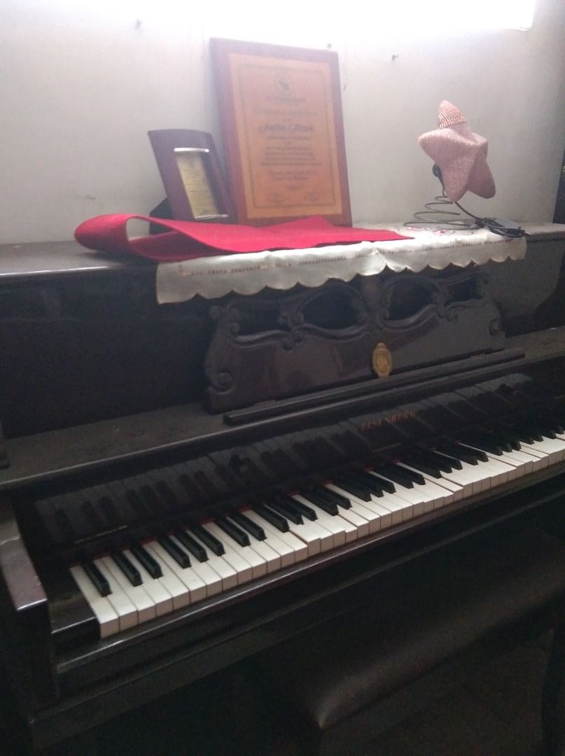 Upright Piano with Bench and Accessories (Category: Musical Instruments) located in Caloocan City. Submitted by lonewolf22 (Listing ID 1464387636, Image 1). Description: - Upright piano - Matching bench included - Decorative items (framed certificate, small hat) on top included - Ideal for music rooms or as a statement piece - Pick up only.