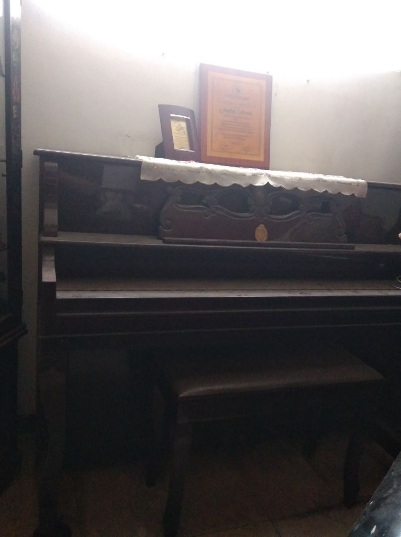 Upright Piano with Bench and Accessories (Category: Musical Instruments) located in Caloocan City. Submitted by lonewolf22 (Listing ID 1464387636, Image 2). Description: - Upright piano - Matching bench included - Decorative items (framed certificate, small hat) on top included - Ideal for music rooms or as a statement piece - Pick up only.