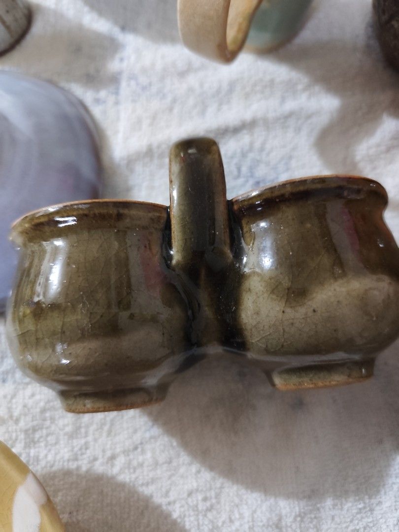 Vintage Ceramic Double Condiment Holder with Handle (Category: Food Organization & Storage) located in Manila. Submitted by marriage031073advocate (Listing ID 1464420410, Image 1). Description: - Unique double-compartment ceramic holder - Rustic, crackled glazed finish - Sturdy handle for easy carrying - Ideal for serving sauces, dips, or spices - Adds vintage charm to any table setting - Great for collectors or unique kitchenware.